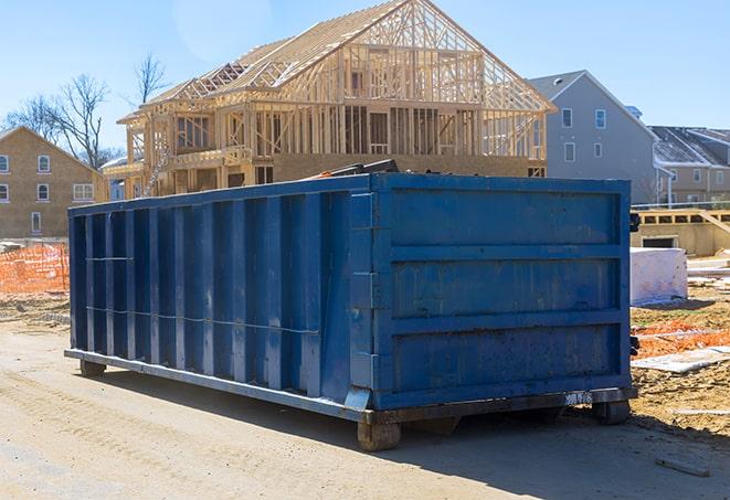 a rusty dumpster overflowing with plastic bags and cardboard boxes on a rural road